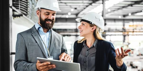 Mann und Frau in Industriehalle mit Tablet