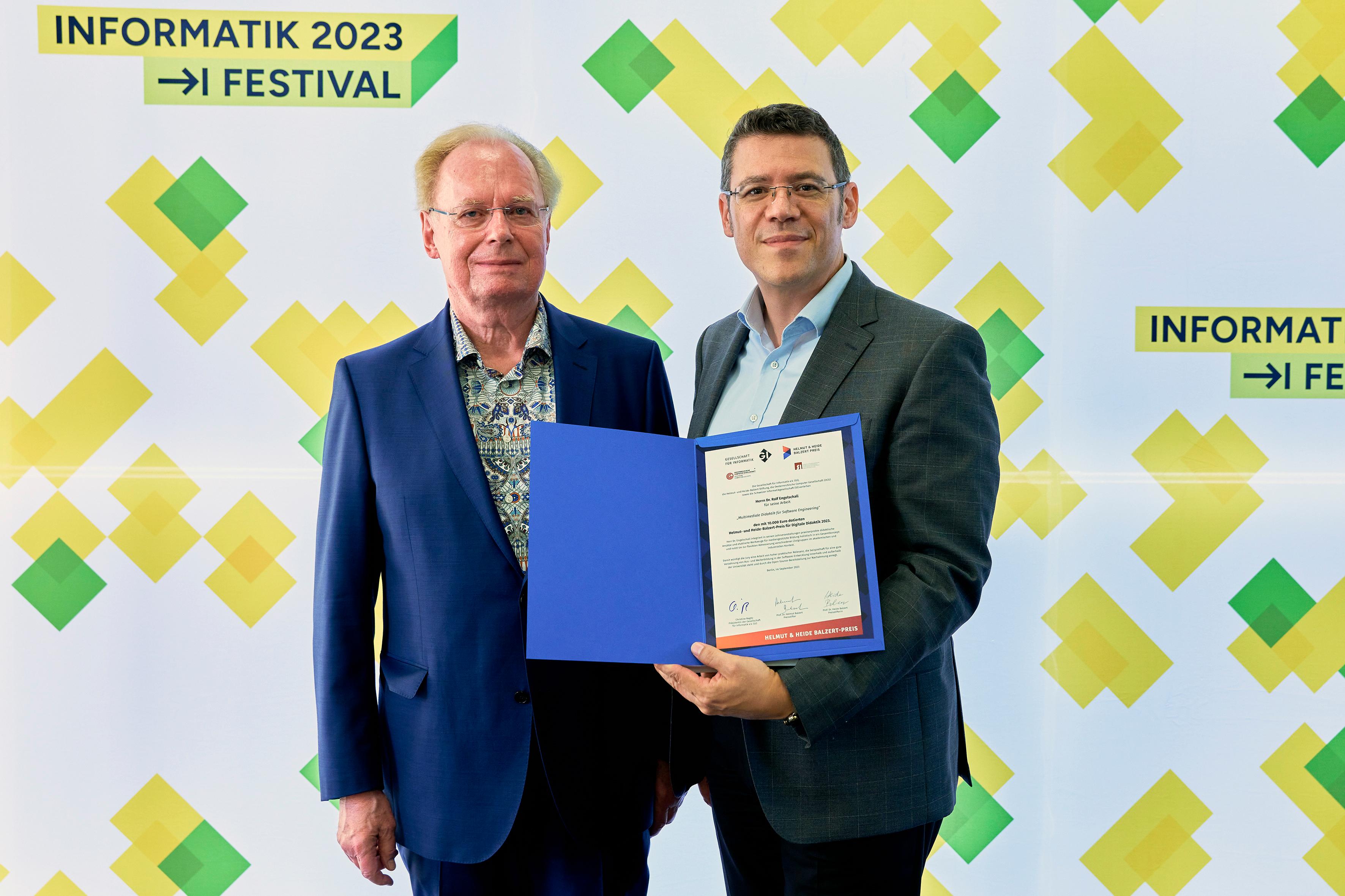 two men are smiling and showing a certificate to the camera