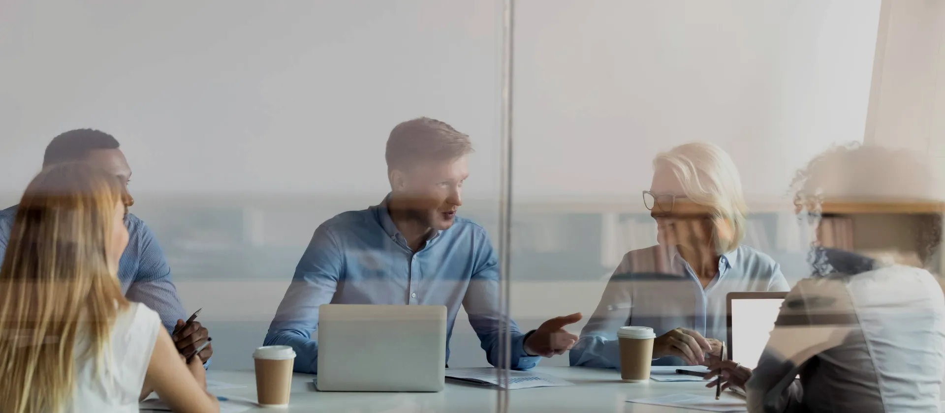 A group of people are sitting at a conference table and having a meeting.