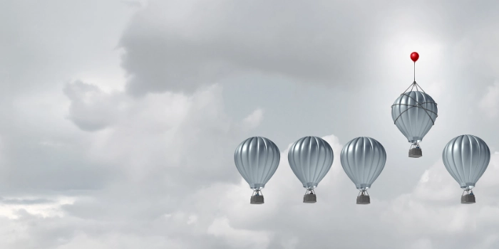 Symbolic image for backtesting in anti-money laundering: A group of hot air balloons, one being lifted by a red balloon – symbolizing comparison, calibration, and targeted optimisation of monitoring parameters.