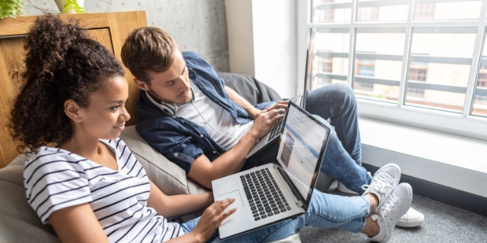 Ein Ausbilder zeigt einer IT-Auszubildenden etwas auf deren Laptop