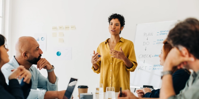 Mitarbeitende im Büro sitzen am Tisch und diskutieren ein Projekt